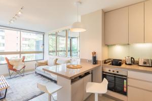 een keuken en woonkamer met een tafel en stoelen bij Luxury Retreat w/ 2BR, Wifi, Pool, Gym in Santiago