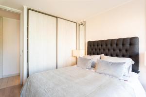 een slaapkamer met een groot bed met witte lakens en kussens bij Luxury Retreat w/ 2BR, Wifi, Pool, Gym in Santiago +17 foto's