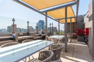 een patio met tafels en stoelen op een dak bij Luxury Retreat w/ 2BR, Wifi, Pool, Gym in Santiago