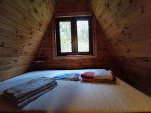 1 dormitorio en una cabaña de madera con ventana en Domek w Brodnicy Dolnej, en Brodnica Dolna