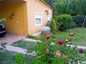 a garden with flowers in front of a house at Casa a 5 km de Villa de Las Rosas in Las Tapias +3 photos