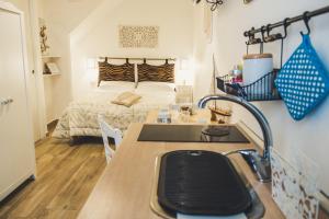 a small room with a bed and a kitchen with a sink at HolidayMonopoli in Monopoli