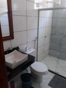 y baño con aseo, lavabo y ducha. en Casa de Temporada Guaibim en Guaibim