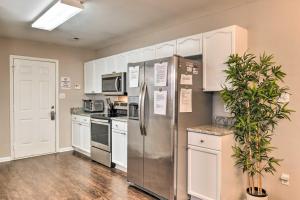 una cocina con electrodomésticos de acero inoxidable y armarios blancos en Updated Charlotte Home with Central AandC - Near UNCC, en Charlotte