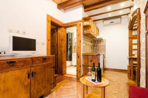 sala de estar con TV y mesa con botellas de vino en Apartment Soul of the Town, en Dubrovnik