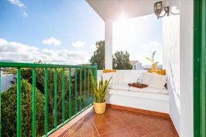 a balcony with a white bench and a view at Surfescape Fuerteventura in Lajares
