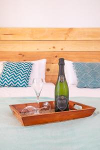 a bottle of wine and a glass in a tray on a bed at Surfescape Fuerteventura in Lajares