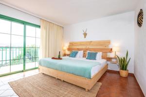 a bedroom with a bed and a large window at Surfescape Fuerteventura in Lajares