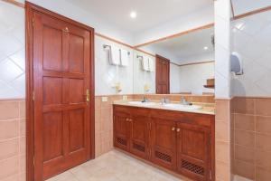 a bathroom with a sink and a wooden door at Surfescape Fuerteventura in Lajares