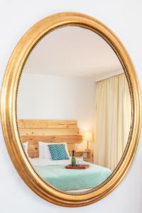 a mirror on a wall with a bed in a room at Surfescape Fuerteventura in Lajares