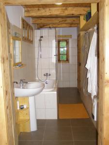 a bathroom with a sink and a bath tub at Casa Emma Ház in Sovata
