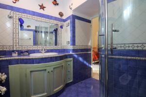 a blue tiled bathroom with a sink and a shower at De Vivo Realty - Ilary House Positano in Positano +48 photos