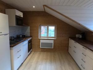 a kitchen with white cabinets and a window at Chez Léa et Lolo - L'Alpina in Gérardmer