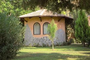 una piccola casa con un piccolo albero nel cortile di BV Borgo Del Principe a Zambrone