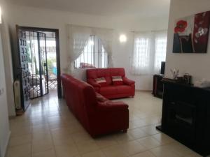 - un salon avec un canapé rouge et une télévision dans l'établissement Pite, à Moraira