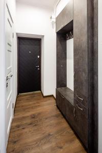 利維夫的住宿－Romari ВІП апартаменти Оперний театр，走廊上设有黑色的门,铺有木地板
