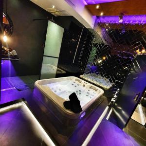 a bath tub in a room with purple lights at Hotel Ramka & Restaurant & Wine Bar in Poznań