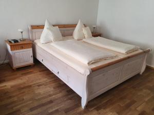 a white bed with white sheets and pillows on it at Hotel Andreasstuben in Weißenburg in Bayern