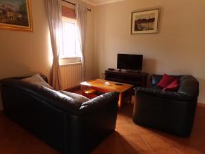 uma sala de estar com duas cadeiras de couro e uma mesa de centro em Casa do Passarinho em Resende
