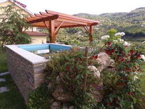 uma piscina com uma pérgula de madeira e algumas flores em Casa do Passarinho em Resende