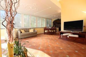 a large living room with a flat screen tv at De Vivo Realty - Ilary House Positano in Positano