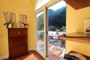 a room with a sliding glass door leading to a patio at De Vivo Realty - Ilary House Positano in Positano