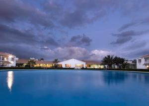 a large swimming pool in front of houses at night at Parador de Málaga Golf in Málaga