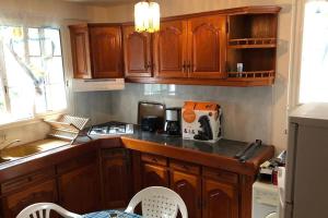 a kitchen with wooden cabinets and a counter top at Saint François Villacoco in Saint-François +5 photos