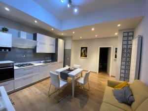 a kitchen and living room with a table and chairs at Marina Apartment & suite in Verbania