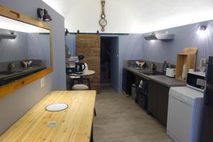 une cuisine avec une table en bois au milieu dans l'établissement Le Bouquiniste, atypique, cosy, fibre, BedinShop, à Romans-sur-Isère