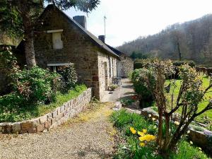 ein Steinhaus mit einer Steinmauer und einem Garten in der Unterkunft Le Moulin L'Eveque in Campeaux + 38 Fotos