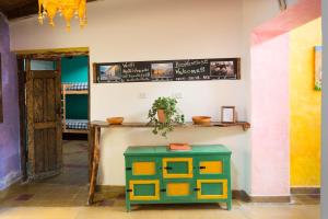 Cette chambre comprend une table et un tabouret vert. dans l'établissement Viracocha Art Hostel Cachi, à Cachí