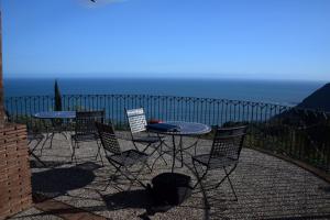 um pátio com uma mesa e cadeiras e o oceano em Villa "Ai Galli" em Terracina