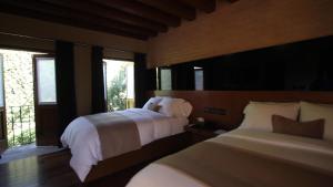 a bedroom with two beds and a window at Hotel Boutique Casa Madero in Morelia