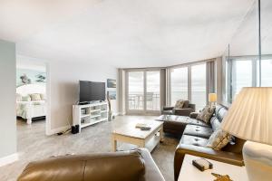 a living room with a couch and a tv at Beach Escape Condos in Daytona Beach Shores
