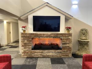 a living room with a fireplace with a tv on top at University Inn of Carbondale in Carbondale