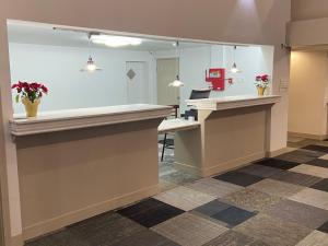 a lobby with a reception desk and a mirror at University Inn of Carbondale in Carbondale