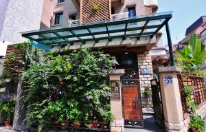 a building with a balcony with flowers on it at 花蓮觀月民宿-近車站-寵物友善-含車位可包棟6-14位 可烤肉-可麻將 in Hualien City