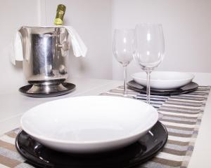 
a white table topped with a white plate topped with a wine glass at Domus Flò in Santa Maria di Castellabate
