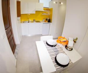 
a kitchen with a white counter top and white cabinets at Domus Flò in Santa Maria di Castellabate
