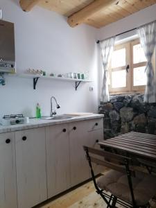 a kitchen with a sink and a table at Garac Zlatibor Vikendica in Zlatibor
