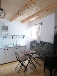 a kitchen with a table and chairs and a stone wall at Garac Zlatibor Vikendica in Zlatibor