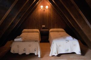 a room with two beds in a attic at Hotel Saueth in Tredós