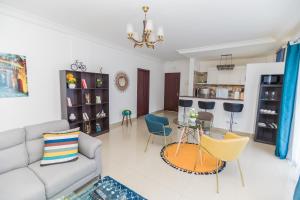 a living room with a couch and a table and chairs at Appartement cosy à la plage - Pointe Noire in Pointe-Noire