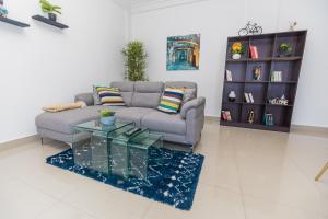 a living room with a couch and a glass coffee table at Appartement cosy à la plage - Pointe Noire in Pointe-Noire