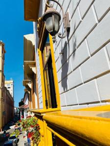 un edificio blanco y amarillo con luz de la calle en Ayenda El Viajero #2, en Cartagena de Indias