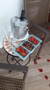 a table with a tray of strawberries and a pot on it at Hotel Boutique Recanto da Passagem in Cabo Frio