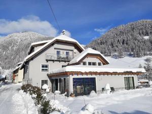 a large white house with snow on top of it at Ferienwohnung Jehsner in Gries
