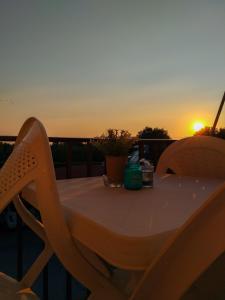 a table on a balcony with the sunset in the background at Eytuxia's Studios in Minia