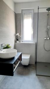 baño con lavabo y aseo y ventana en Molo Wellness Garden, en Siófok